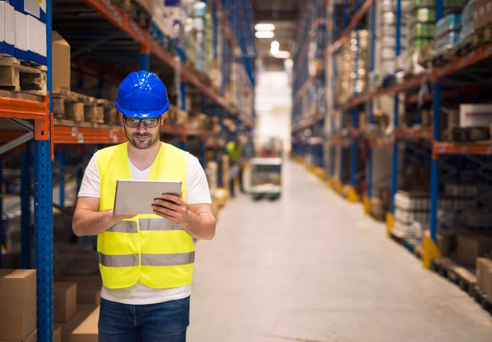 warehouse-worker-checking-inventory-his-tablet-while-walking-large-storage-department-with-shelves-packages-background (1) (1)
